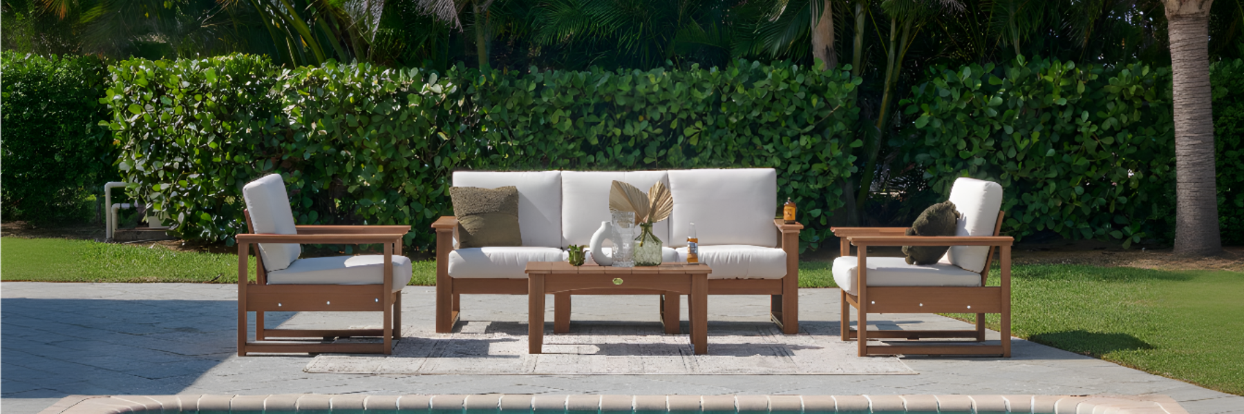 Outdoor furniture set with a sofa and chairs by a poolside