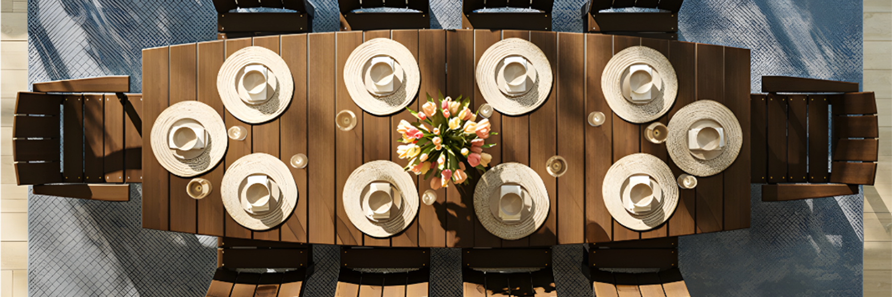 Wooden outdoor dining table with chairs and white plates on a blue and gray patterned rug.